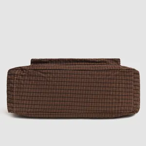 Brown plaid fabric bag bottom detail view, casual style textured woven tote structure base.