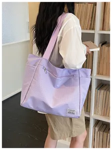 Détail de sac cabas texture grille violet clair, sac bandoulière élégant pour travail quotidien.