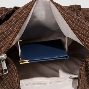 Close-up interior view of a brown grid shoulder bag showing lining and pocket details.