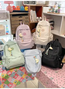 Detailed view of cute diamond quilted casual backpacks in multiple colors with lovely charms for daily use.