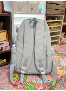 Light blue quilted backpack detail, casual daily school bag with shoulder straps and pockets.