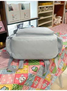 Light blue quilted backpack for casual travel, stylish diamond pattern school bag for daily use.