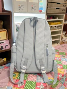 Light blue quilted casual backpack, back view showing adjustable straps and pocket design.