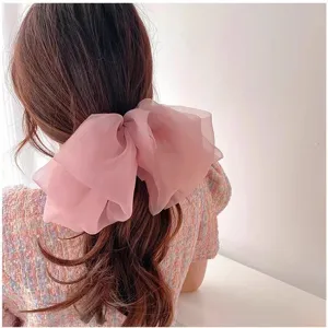 Pink chiffon bow hair clip for women, elegant large hair accessory for ponytail styling.