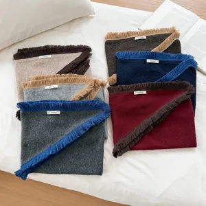 Vue détaillée d'écharpes triangulaires en tricot douillet à franges, multicolores.