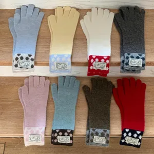 Vue détaillée de gants en tricot d'hiver chauds avec étiquettes de lapin et pois colorés.