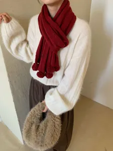 Vue détaillée d'une écharpe en tricot chaud style coréen douillet avec de charmants pompons mignons.