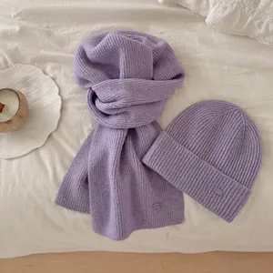 Vue détaillée de l'ensemble écharpe et bonnet en tricot mauve d'hiver, chaud et épais cozy.