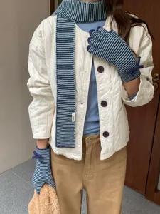 Gros plan d'une écharpe rayée et de gants tactiles avec nœud pour l'hiver douillet.