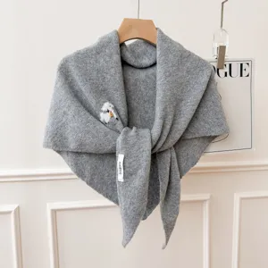 Vue détaillée de l'écharpe en tricot gris avec texture fine et charmante broderie.