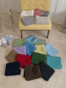 Vue détaillée de plusieurs écharpes en tricot uni de diverses couleurs, doux.