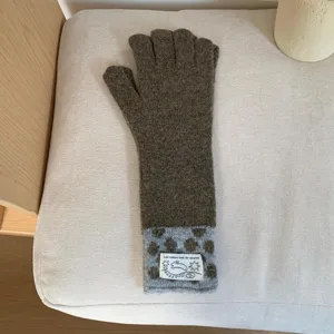 Gros plan de gants tactiles en tricot avec poignet à pois et joli détail d'étiquette.