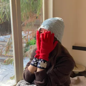 Vue détaillée de gants en tricot chaud rouge vif avec des poignets douillets à pois d'hiver.