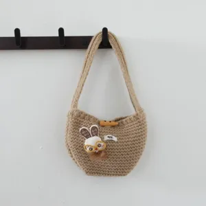 Vue détaillée du sac à main en tricot avec broderie de lapin et bouton en corne.