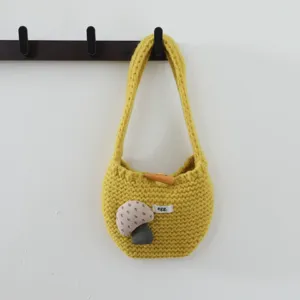 Détail sac à main en tricot jaune, charmante déco champignon, mini sac tissé doux.