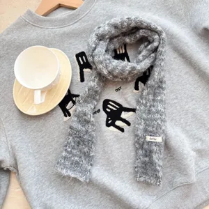 Vue détaillée de l'écharpe en tricot gris, texture douce et accessoire d'hiver cosy.