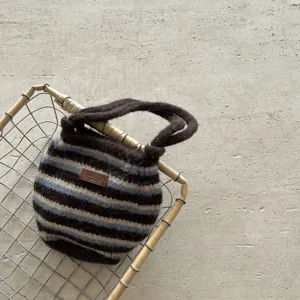 Vue détaillée d'un mini sac à main élégant en tricot rayé avec un design de couleur contrastée.