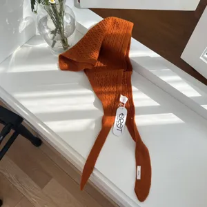 Vue rapprochée détaillée montrant la texture du tissu foulard triangulaire en tricot orange