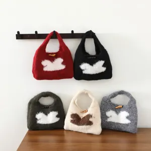 Gros plan de sacs à main en tricot mignons avec motifs de lapin et boutons en bois multicolores.