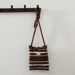 Vue détaillée du sac à bandoulière en tricot rayé marron et blanc sur le crochet