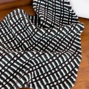 Vue detaille de l'echarpe en tricot de laine carreaux style koreen, texture confortable.
