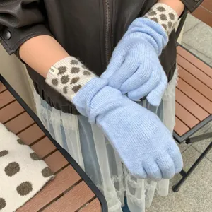Gros plan sur des gants longs en tricot douillet avec des poignets à pois élégants.
