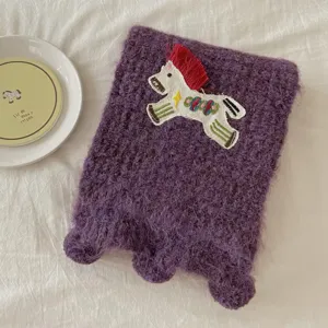 Purple knit scarf detail showing cute horse embroidery and cozy plush texture for winter.