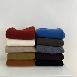 Vue détaillée d'écharpes en tricot multicolores empilées proprement sur une surface.