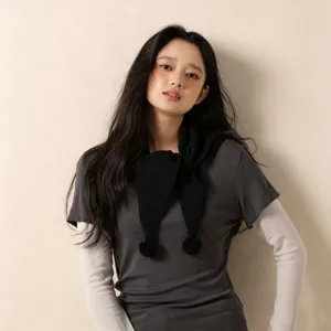 Vue détaillée d'écharpe col en tricot noir avec pompon pour femmes, accessoire mode hiver.