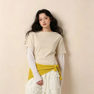 Vue détaillée de la tenue superposée élégante avec t-shirt beige, jupe blanche et pull jaune.