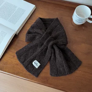 Detailed view of the dark brown woolen cross knit scarf, showcasing soft texture and cozy wear.