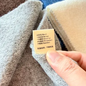 Gedetailleerde close-up van het sjaalverzorgingslabel met wolmix materiaalsamenstelling.