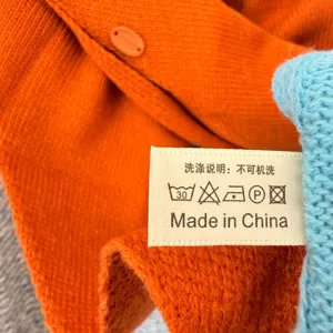 Vue rapprochée montrant l'étiquette d'entretien et la texture du tissu tricoté.