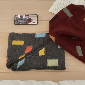 Vue détaillée de l'élégante écharpe en tricot colorée avec des motifs géométriques très doux.