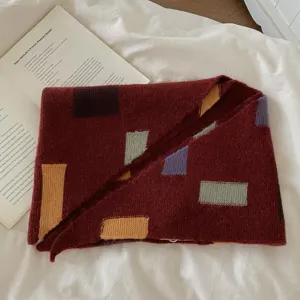 Gros plan détaillé d'écharpe tricotée en bloc de couleur, motif géométrique hiver chaud.