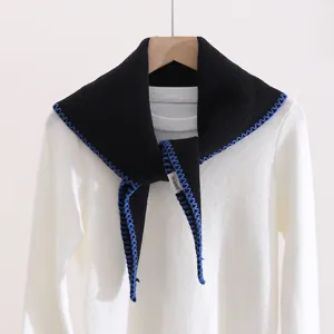 Detailed view of the stylish black knitted triangle scarf with blue contrast stitching.