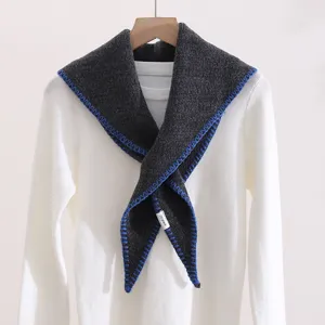 Dark grey knit triangular shawl scarf with contrast blue locking edge detail close up.