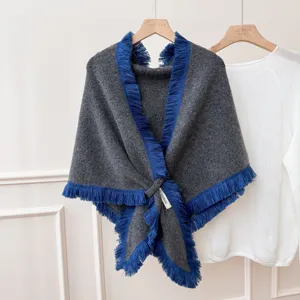 Vue détaillée du châle triangulaire en tricot gris rétro avec franges bleues et design.