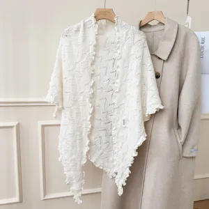 Scialle in maglia bianca con bordo volant, comoda mantella invernale e dettaglio rétro chic.