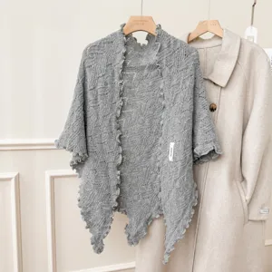 Scialle triangolare in maglia traforata grigia con delicati volant, elegante mantella invernale.