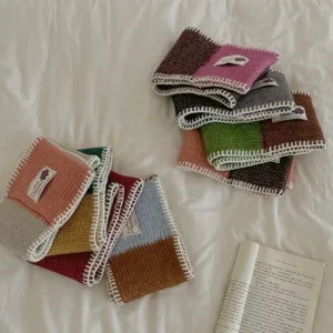 Close-up of color-block knitted wool-blend mini scarf details, cozy and soft texture.