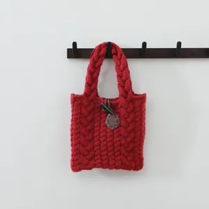 Détail de sac cabas en tricot torsadé rouge, vue de poignée de sac à main d'hiver