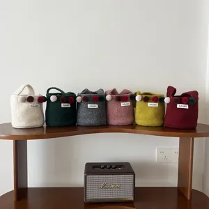 Sac seau en feutre vue de détail, sacs en laine colorée avec pompons et belle étiquette.