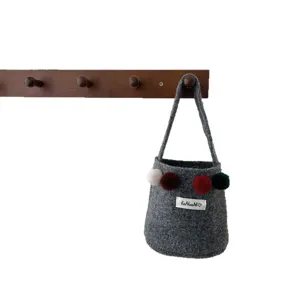 Sac seau en feutre gris avec de jolies pompons colores et une petite etiquette tisee.