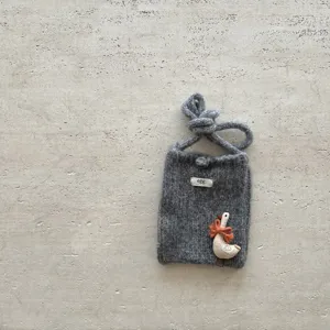 Vue détaillée du mini sac de téléphone en tricot gris avec charm oie et étiquette.