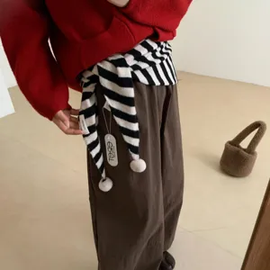 Gros-plan détaillé de l'écharpe tricotée rayée noir et blanc avec de jolis pompons mignons.