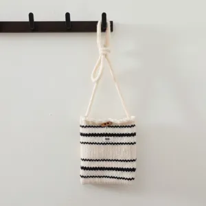 Vue de détail du mini sac bandoulière en tricot avec des rayures noires et blanches.
