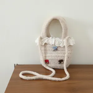 Nahaufnahme des bezaubernden Strick-Plüschhandtasche mit feiner Häkelstruktur und Spitzenbesatz.