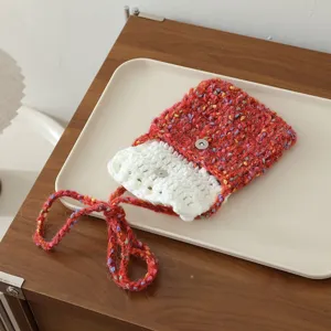 Gros plan d'un mini sac fourre-tout rouge en laine crochetée main avec bouton-pression et lanière.