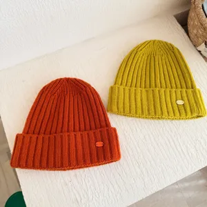 Bonnet en tricot côtelé d'hiver confortable en orange et jaune vifs pour femmes.